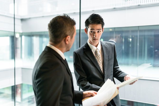 立ちながら会話をしているビジネスマン