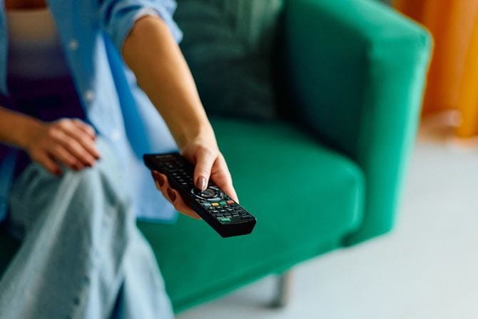 テレビのリモコンを操作する女性