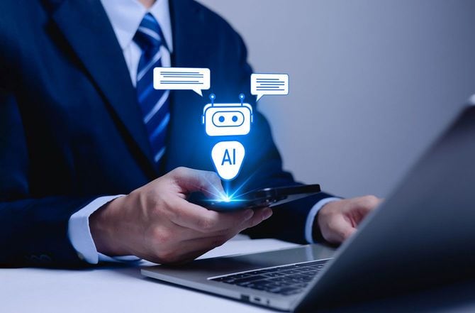 スマホでAIとチャットをしながらパソコンを使用している人
