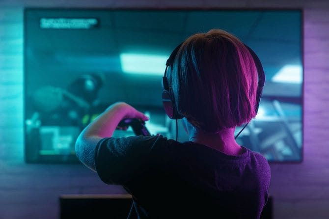 暗い部屋でビデオゲームをしている男の子
