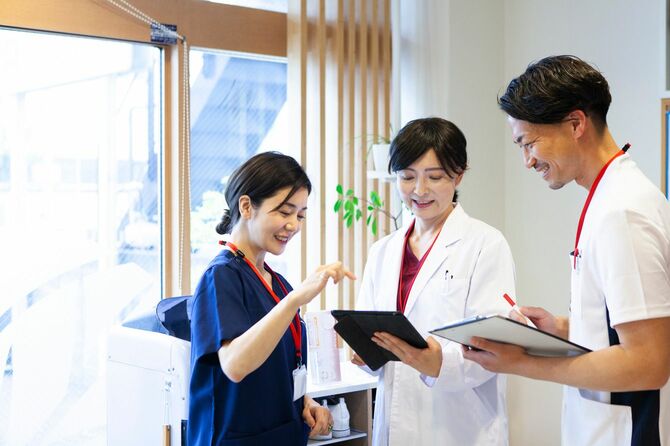 病院のロビーで会話する医師とスタッフ