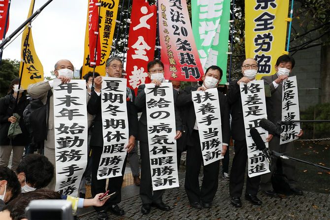 日本郵便非正規格差をめぐる訴訟で「勝訴」の垂れ幕を掲げる原告団=2020年10月15日、東京都千代田区