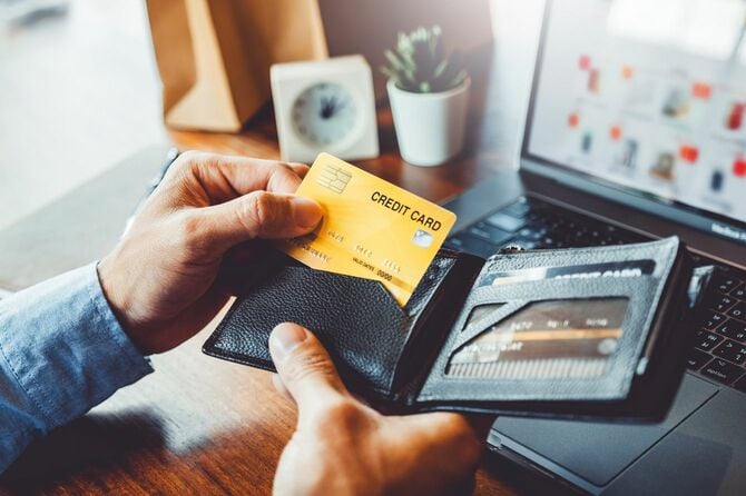 クレジットカードを財布から取り出す男性