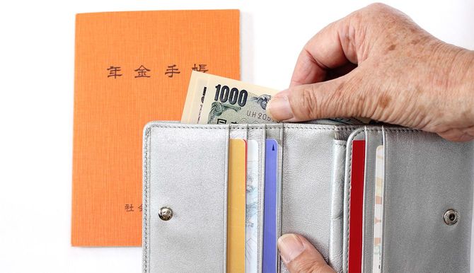 年金手帳と、財布からお金を出す人の手
