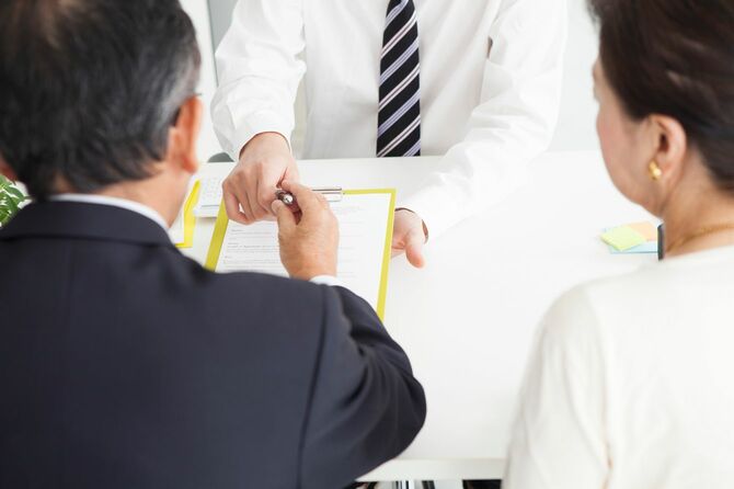 紙とボールペンを渡される夫婦