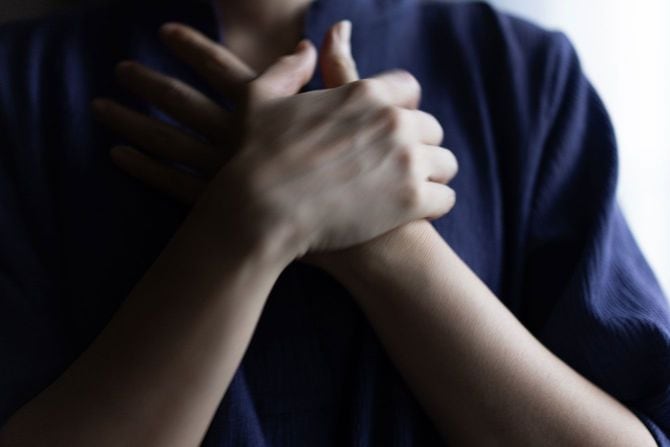 胸に手を当てる人