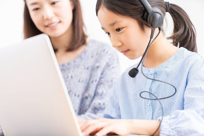 娘のオンライン授業をそばで見守る母親