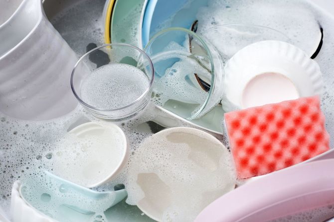 水の中の皿とボウル、そして食器用洗剤の泡
