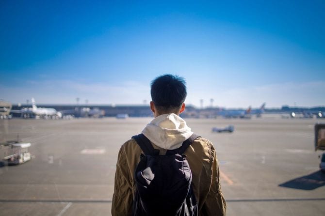 空港からの眺めを見る10代の少年