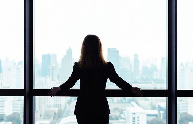 窓の外の都市をみる女性