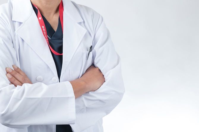 白衣を着た医師が腕を組んでいる