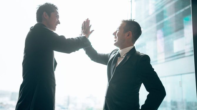 ハイファイブする2人のビジネスマン