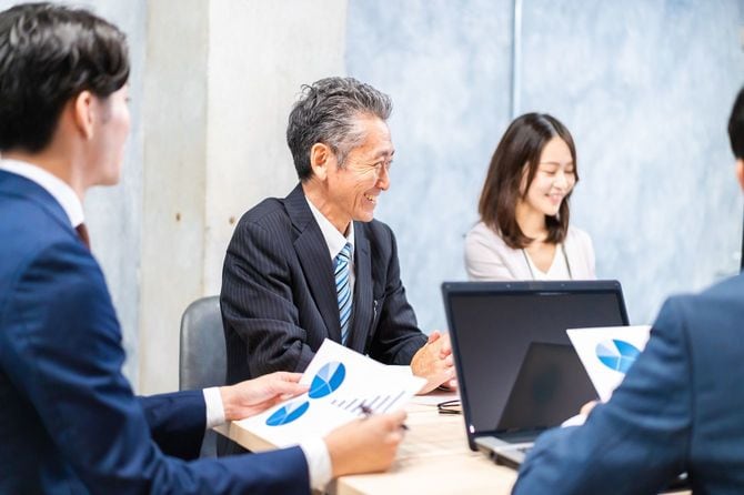 ミーティング中に実に楽しそうな笑顔をみせるシニア男性