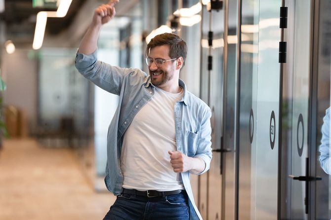 オフィスの廊下で喜ぶ男性