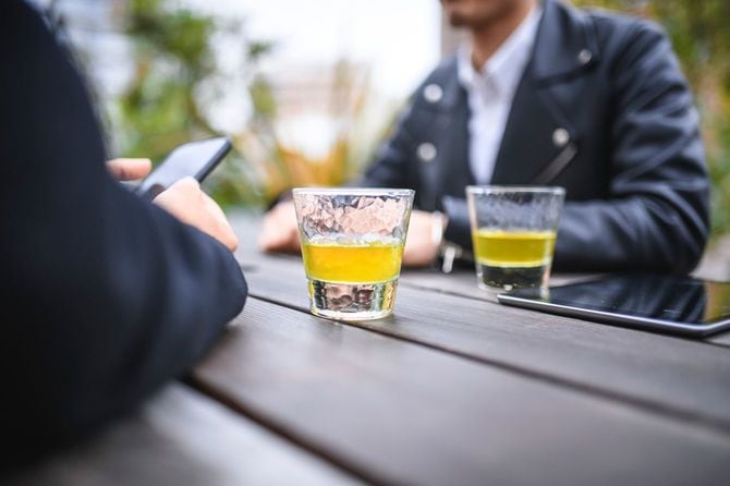 屋外庭園でお茶を楽しむ男性社員たち