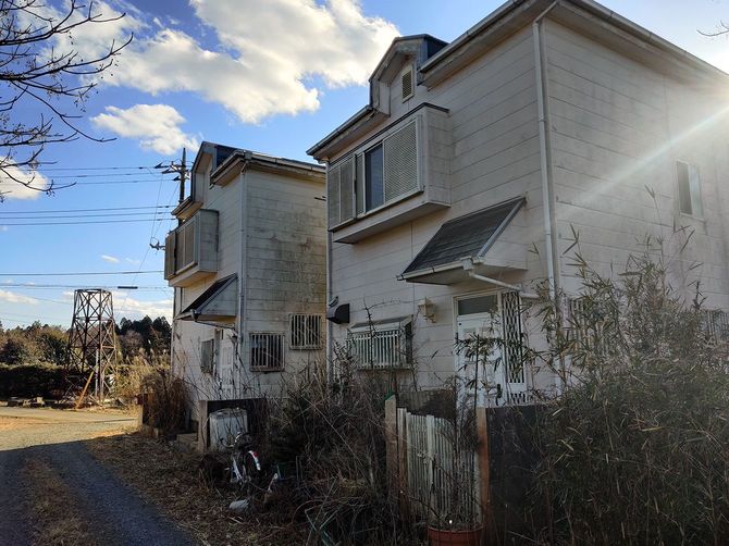 家財道具や自転車が放置され、藪に埋もれた空き家。（千葉県多古町出沼）