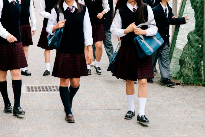 学校の外を歩く日本の高校生たち