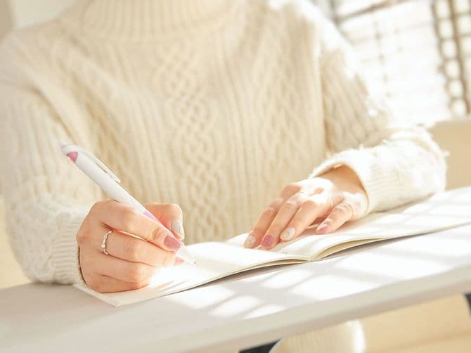 ノートにメモを取る女性