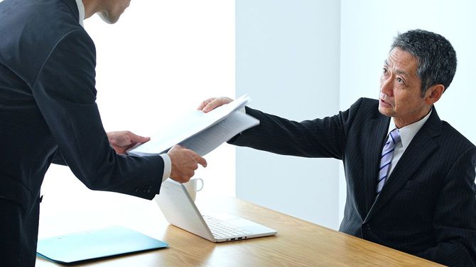 オフィスで部下に指示をする上司