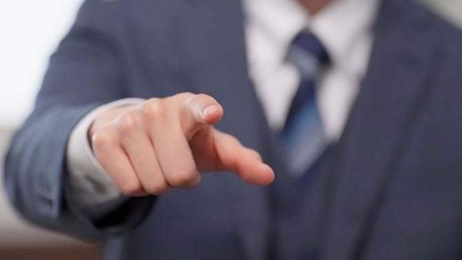こちらに向かって人差し指を突き出しているビジネスマン