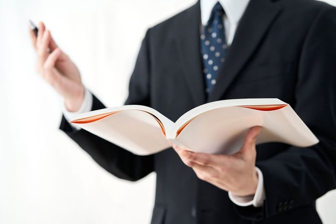 テキストを持って授業を行う塾講師
