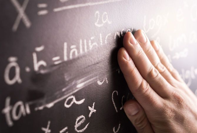 黒板に書かれた数式を手で消す様子