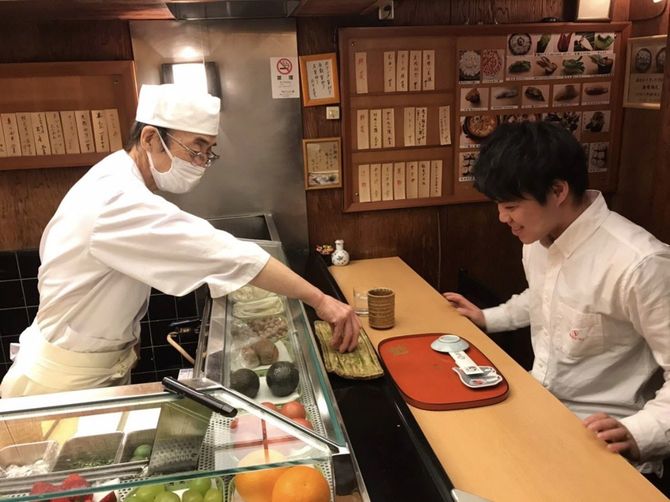 マスクをして接客する大将と寿司を前に笑顔の寿司リーマンさん