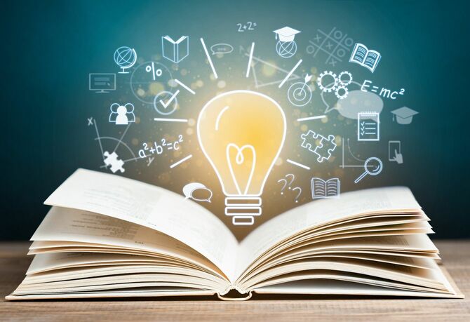 書籍と電球の周りのアイデア、ひらめきのイメージ