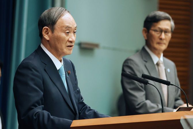 記者会見する菅義偉首相（左）。右は政府の新型コロナウイルス感染症対策分科会の尾身茂会長
