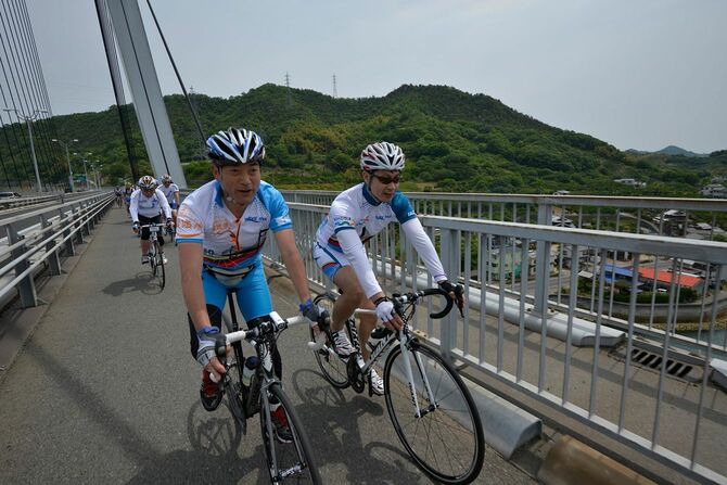 「しまなみ海道サイクリング」で並んで走る愛媛県の中村知事（左）と広島県の湯崎知事
