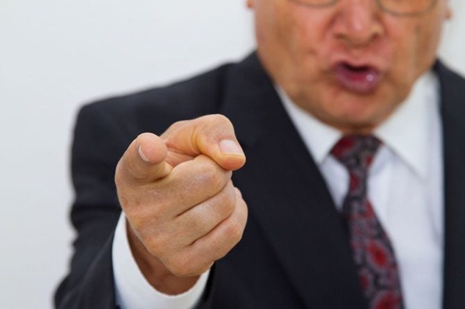 こちらを指さし、激昂している男性