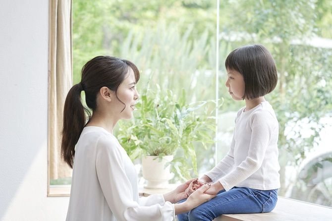子供と向き合って話をする母親