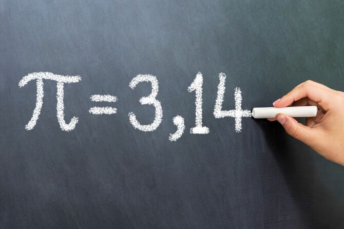 黒板に円周率を書いている手元