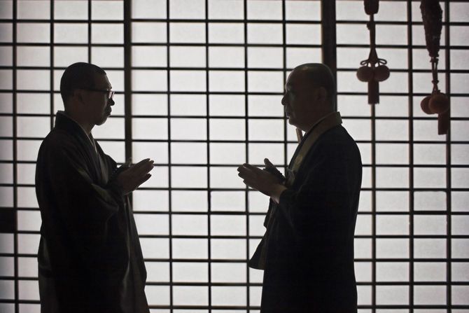 向かい合って手を合わせている二人の僧侶