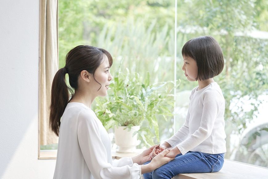 子供と向き合って話をする母親