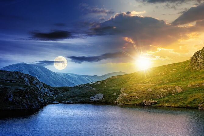 太陽と月が出ている湖の風景