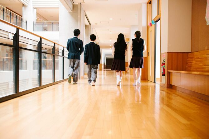 学校の廊下を歩く4人の学生