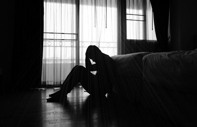 暗い部屋で頭を抱える男性