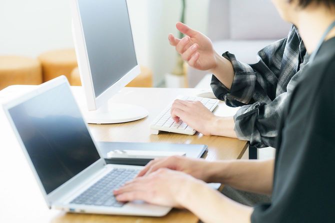 オフィスでパソコンを使用する2人のビジネスパーソン