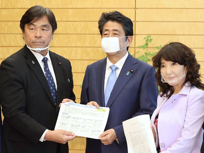 自民党スポーツ立国調査会長の馳浩元文部科学相（左）から提言書を受け取る安倍晋三首相（中央）＝2020年6月23日、首相官邸