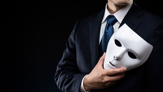 マスクを手にしたスーツの男性