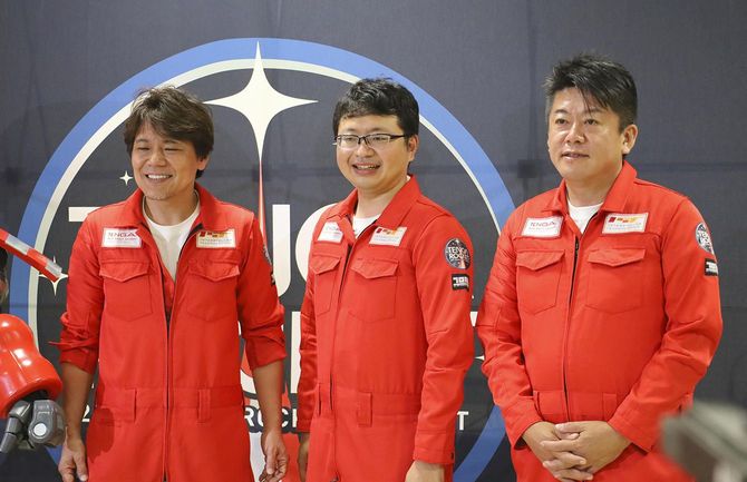 小型ロケット「MOMO」6号機の打ち上げが成功し、記念撮影に応じる「インターステラテクノロジズ」の稲川貴大社長（中央）と創業者の堀江貴文氏（右）ら＝2021年7月31日夜、北海道大樹町