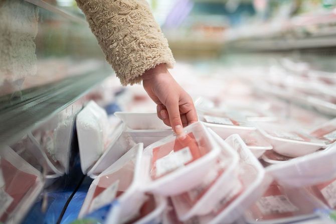 スーパーで魚を選ぶ人の手