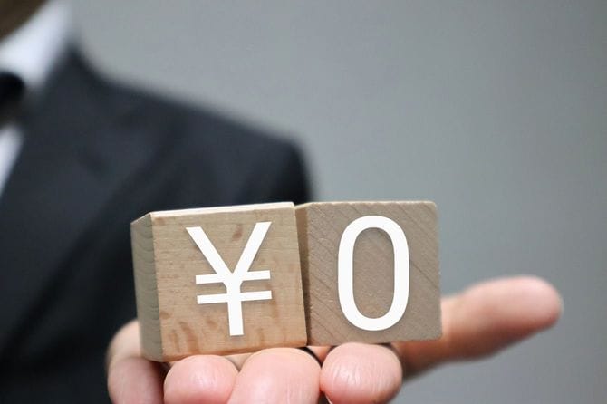 「0円」と書かれたブロックを持つ人