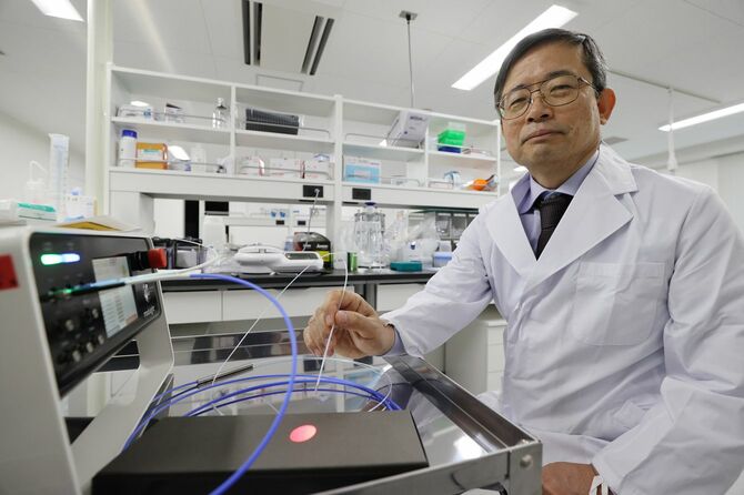 「光免疫医学研究所」でレーザー光を照射してみせる小林久隆所長