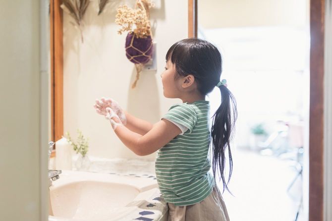 洗面所で手を洗う少女