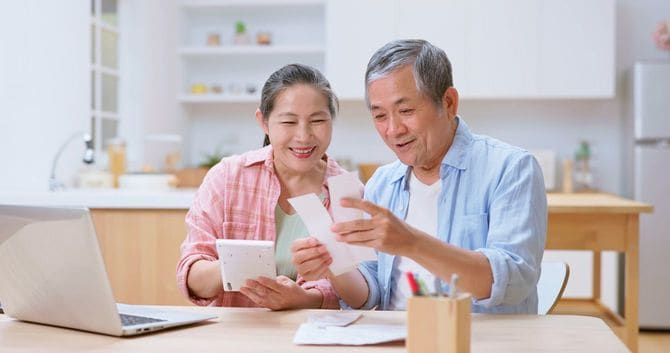 レシートを見ながらお金の計算をする老夫婦