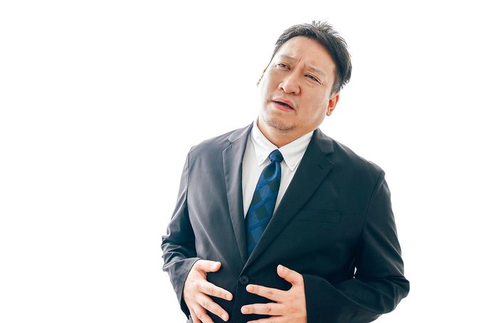 腹痛に苦しむスーツを着た中年男性