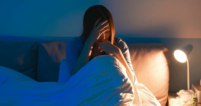 女性は寝室で落ち込む