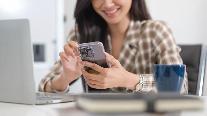 スマートフォンを使って笑顔の女性